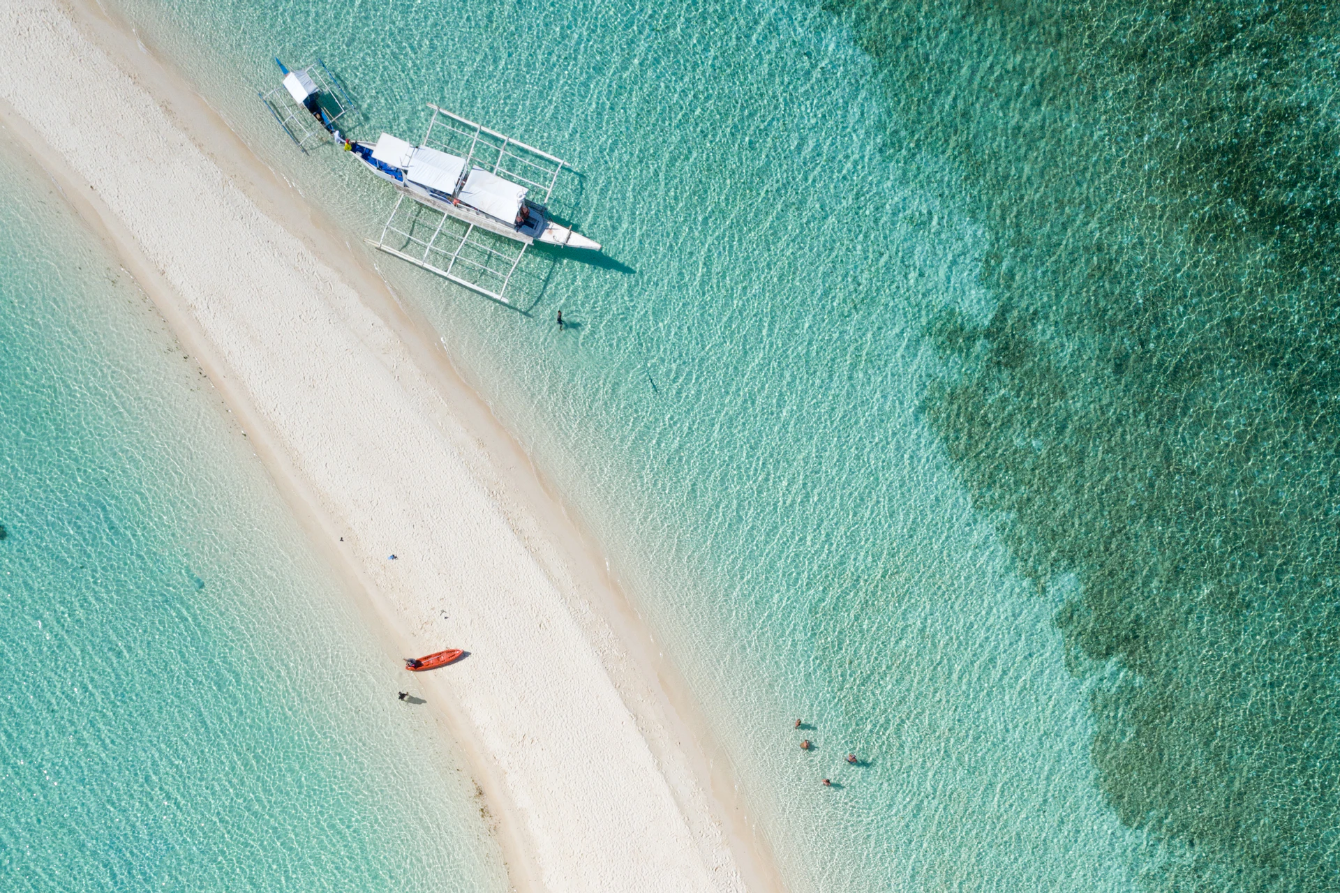 Aerial view of a pale sand spit dividing shallow turquoise water
